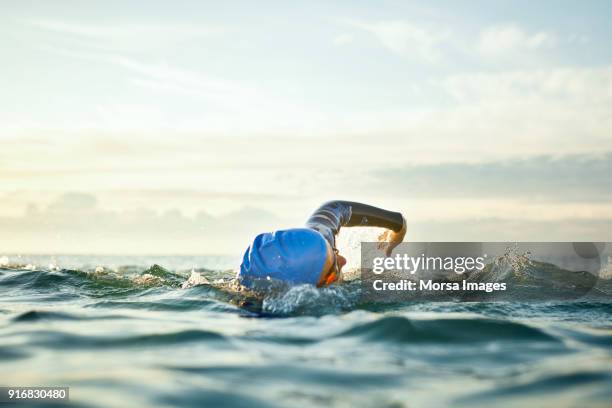 vastberaden vrouw zwemmen in zee - swimming stockfoto's en -beelden