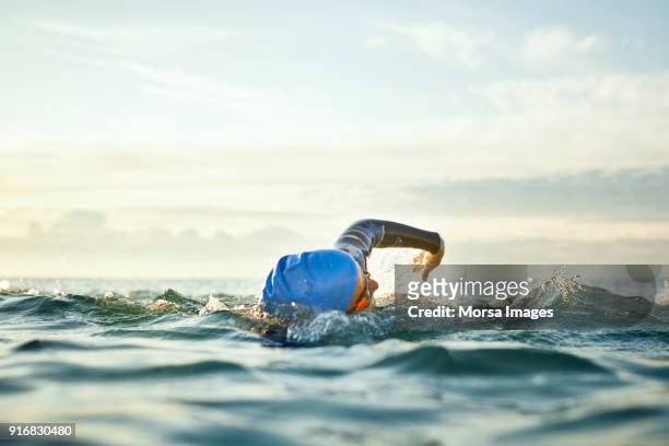 determined woman swimming in sea - image focus technique stock pictures, royalty-free photos & images