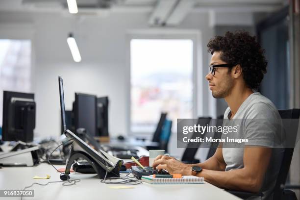 geschäftsmann mit laptop am schreibtisch in büro - profile laptop sitting stock-fotos und bilder