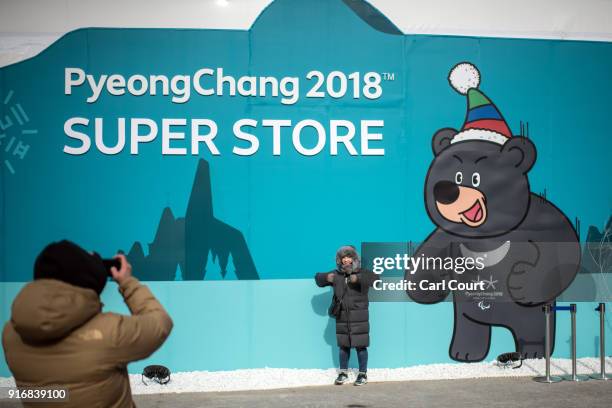 Woman has her photograph taken next to an Olympic mascot on a wall in PyeongChang Olympic Stadium on February 11, 2018 in Pyeongchang-gun, South...