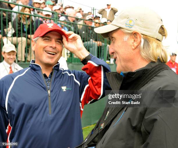 Team captain Fred Couples, left, and International team captain, Greg Norman, right, chat at the first tee box during the second round four-ball...