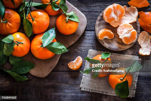 verse biologische mandarijnen op rustieke houten tafel - mandarijn stockfoto's en -beelden