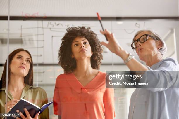 businesswomen discussing plan on glass wall - pensioners demonstrate in barcelona stock pictures, royalty-free photos & images