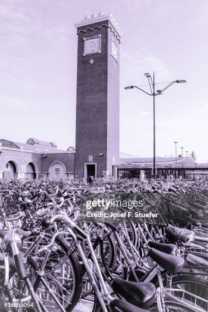 purple city scene, bikes parked at railway station - gelderland bildbanksfoton och bilder