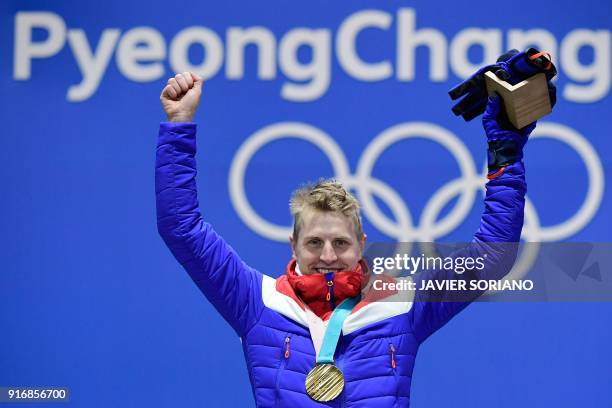 Norway's gold medallist Simen Hegstad Krueger poses on the podium during the medal ceremony for the cross country 15km + 15km skiathlon at the...