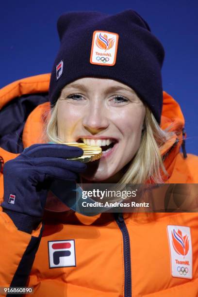 Gold medallist Carlijn Achtereekte of the Netherlands bites her medal as she celebrates on the podium during the Medal Ceremony for the Ladies' Speed...