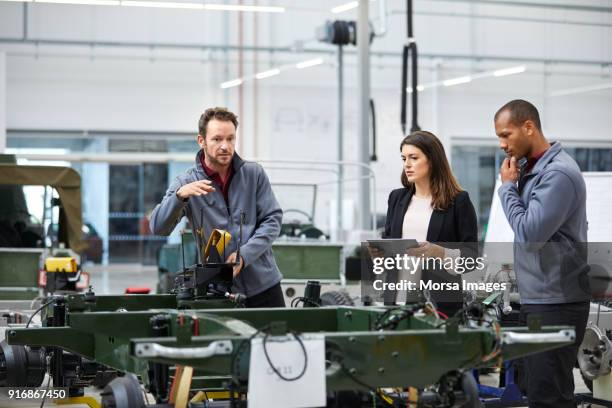 discutir con colegas en la fábrica del coche del ingeniero - car manufacturing fotografías e imágenes de stock