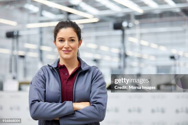 vrouwelijke ingenieur met armen gekruist in autofabriek - factory engineer woman stockfoto's en -beelden