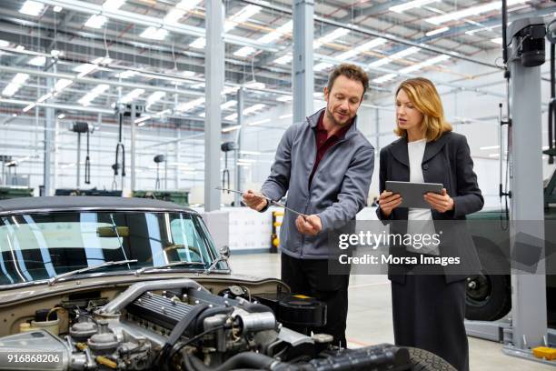 engineer showing dipstick to supervisor by car - dipstick stock pictures, royalty-free photos & images