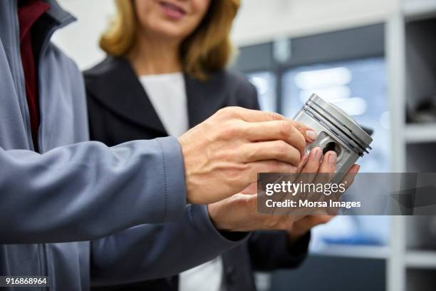 cropped image of engineer with piston by manager - piston stock pictures, royalty-free photos & images