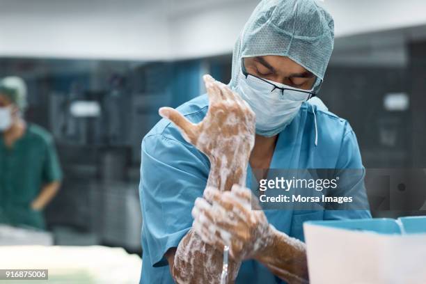 male veterinarian washing hands with soap - man wearing protective face mask stock pictures, royalty-free photos & images