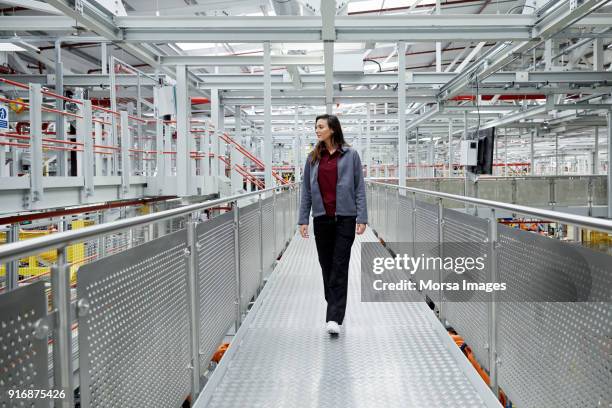 female car engineer walking on elevated walkway - metal catwalk stock pictures, royalty-free photos & images
