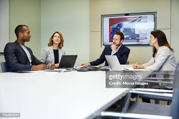 professionals at conference table in board rom - conference rom stock pictures, royalty-free photos & images