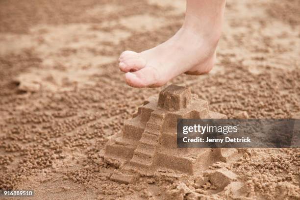 stomping a sand castle - kind sandburg stock-fotos und bilder