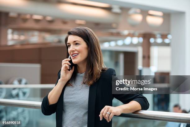 businesswoman talking on smart phone in office - preppy stock pictures, royalty-free photos & images