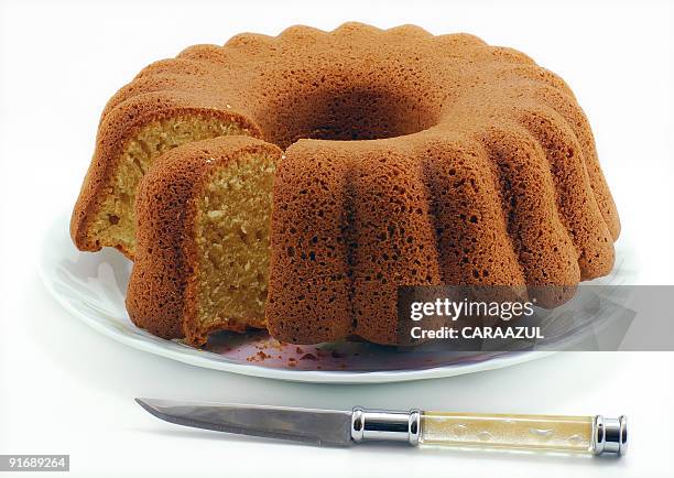 knife cutting a bundt cake on a white plate - cake isolated stock pictures, royalty-free photos & images