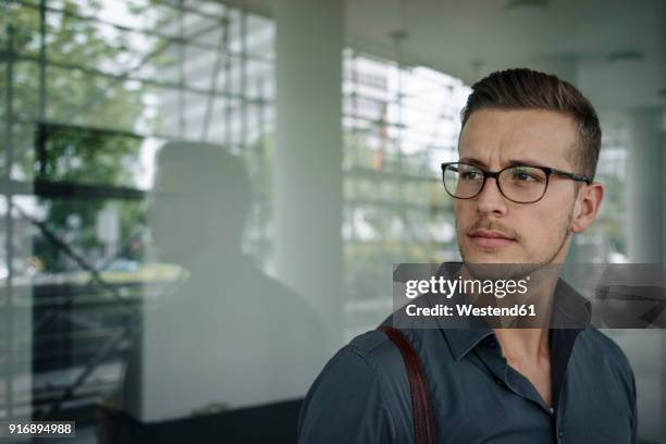 portrait of pensive young businessman wearing glasses - portrait of pensive young businessman wearing glasses stock pictures, royalty-free photos & images