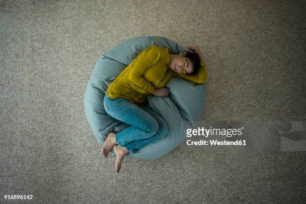 woman sleeping on bean bag at home, top view - beanbag photos et images de collection