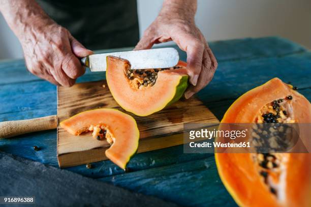 hands of senior man cutting papaya - fruit exotique photos et images de collection