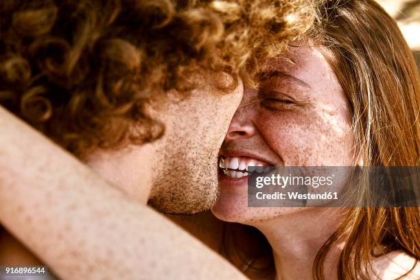 happy young couple hugging - cheveux roux photos et images de collection