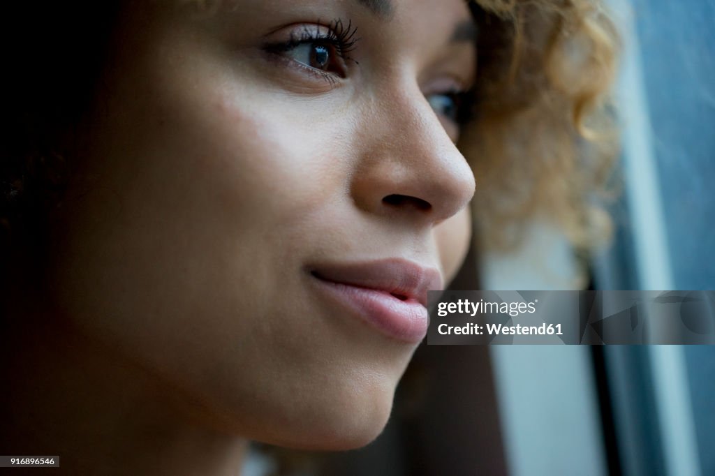 Portrait of smiling woman looking out of window