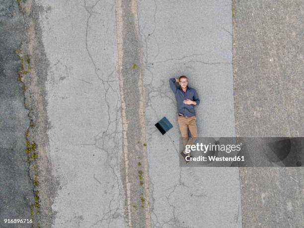 young businessman with laptop relaxing in solitude, quadcopter view - hands behind head stock pictures, royalty-free photos & images