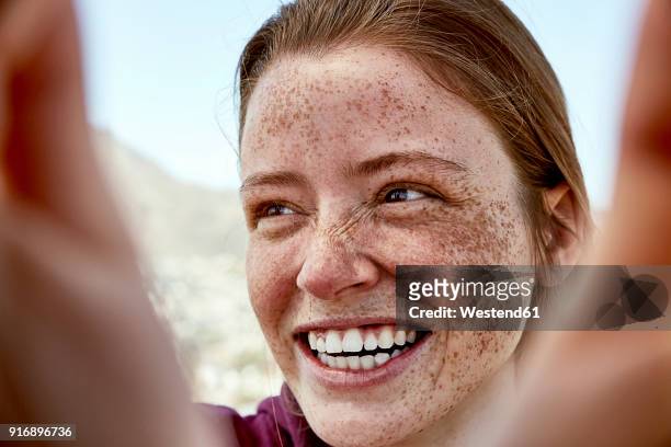 portrait of laughing young woman with freckles outdoors - blickwinkel der aufnahme stock-fotos und bilder