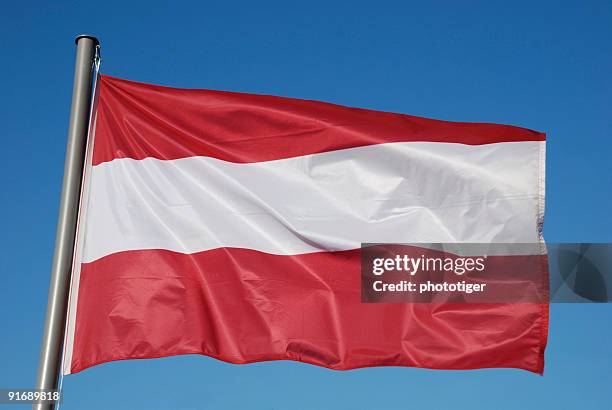 österreichische flagge mit blauem himmel - austria flag stock-fotos und bilder