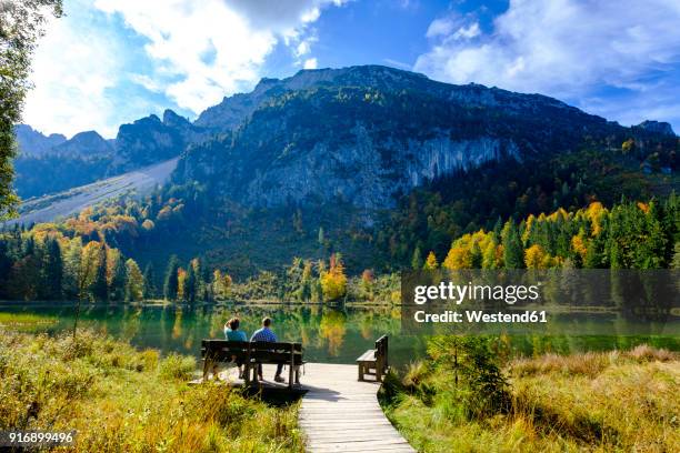 germany, bavaria, upper bavaria, chiemgau, inzell, frillensee, hikers sitting on bench in autumn - bayern menschen stock-fotos und bilder