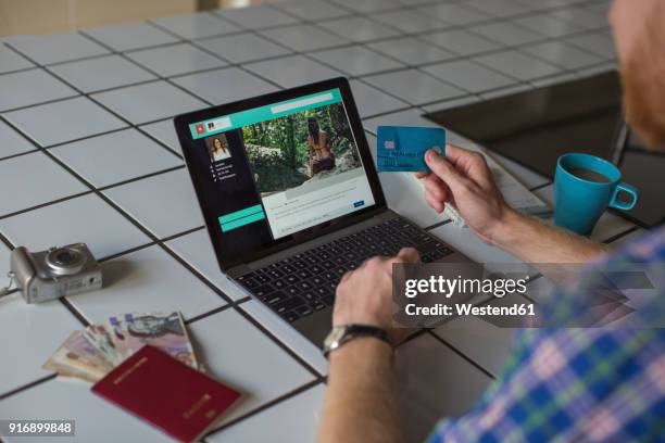 man using credit card and laptop at home - booking holiday stock pictures, royalty-free photos & images