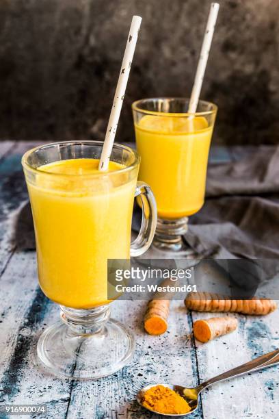 two glasses of curcuma milk - curcuma stock pictures, royalty-free photos & images