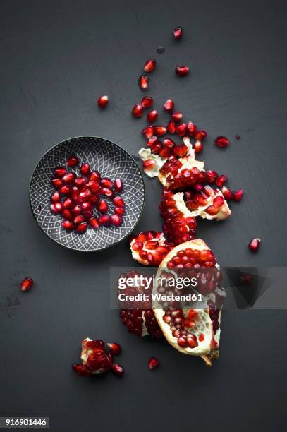 pomegranate and pomegranate seeds in bowl - granatapfel stock-fotos und bilder