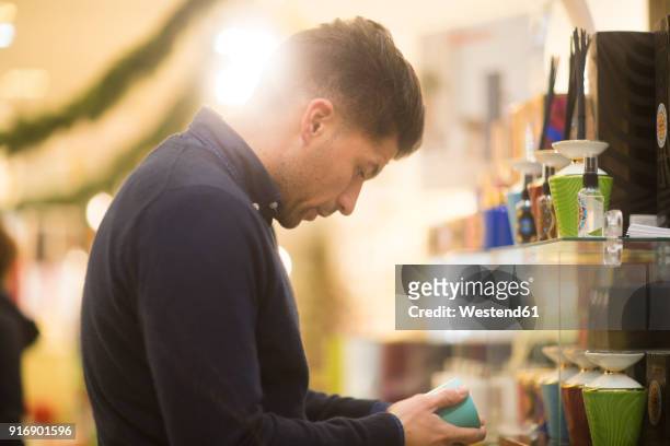 uncertain man looking for christmas present in a shop - choosing perfume stock pictures, royalty-free photos & images