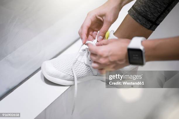 close up of female hands tying sneakers with smartwatch - tie close up fotografías e imágenes de stock