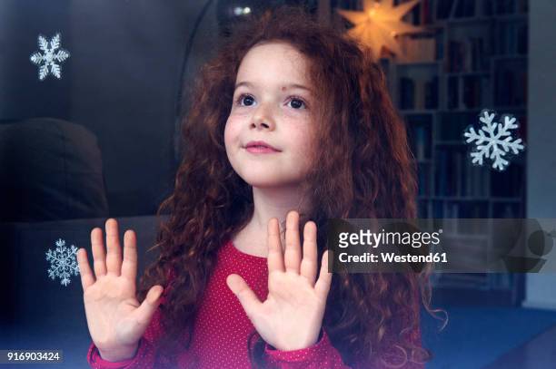 little girl standing at the window, waiting for christmas - advent stock-fotos und bilder