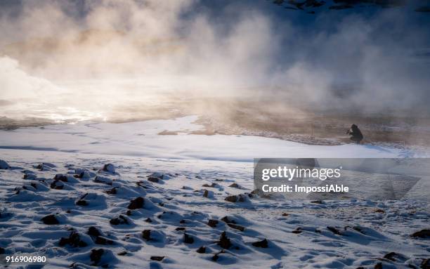 one woman sitting taking picture with her camera at kafla lava field in winter iceland - impossiable fotografías e imágenes de stock