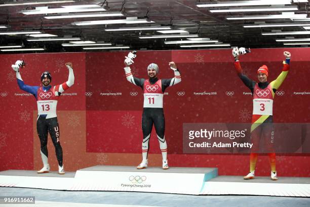 Medalists - Chris Mazdzer of the United States, David Gleirscher of Austria and Johannes Ludwig of Germany celebrate at the flower ceremony following...