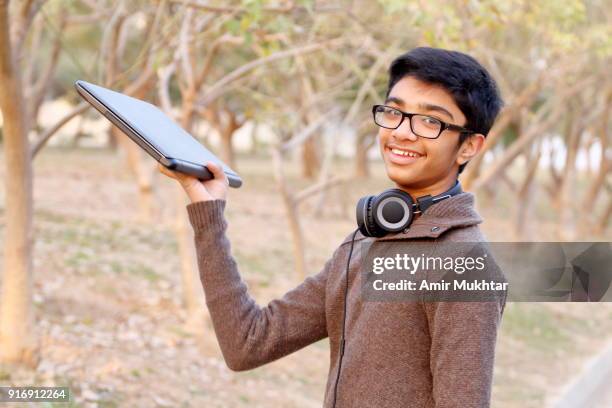 a young boy passing away a laptop to someone - parcel laptop stock pictures, royalty-free photos & images