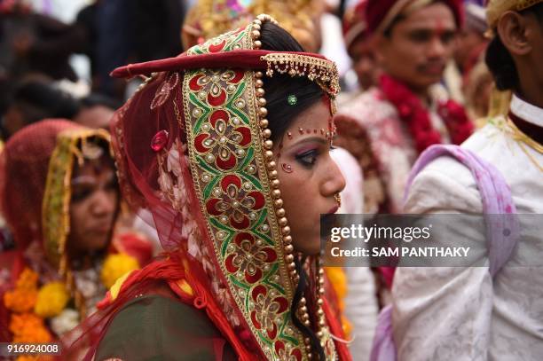 An Indian bride looks on during a mass wedding for members of the Adivasi Bhil tribal community in Ahmedabad on February 11, 2018. Some 35 couples...