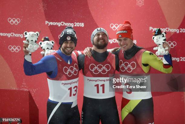 Chris Mazdzer of the United States, David Gleirscher of Austria and Johannes Ludwig of Germany celebrate at the flower ceremony following the Luge...