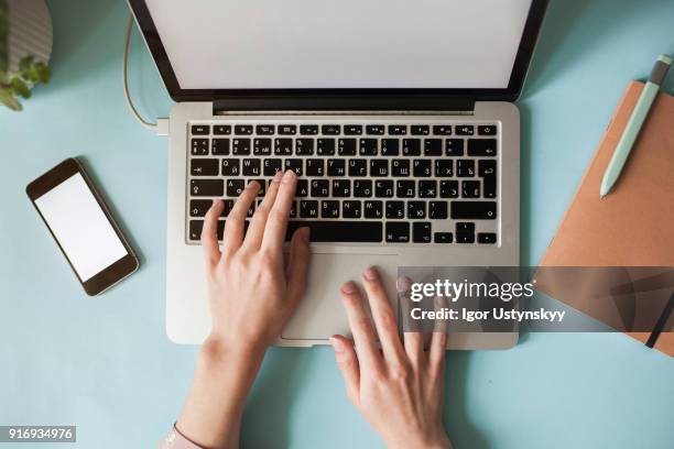 high view of caucasian woman using laptop at table - computertastatur stock-fotos und bilder