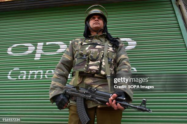 An Indian Paramilitary soldier stands alert near closed shops during shutdown in Srinagar, India administered Kashmir. Curfew-like restrictions have...