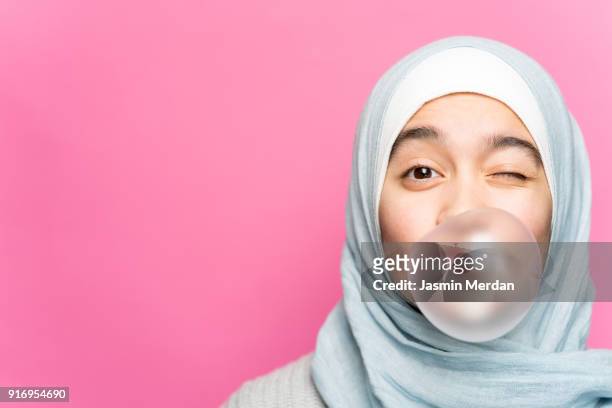 portrait of happy muslim girl with chewing gum - arab youth stock-fotos und bilder