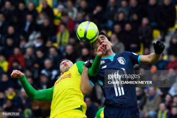 Lille's Paraguay defender Junior Alonso jumps for the ball with Nantes' Argentinian forward Emiliano Sala during the French L1 football match between...