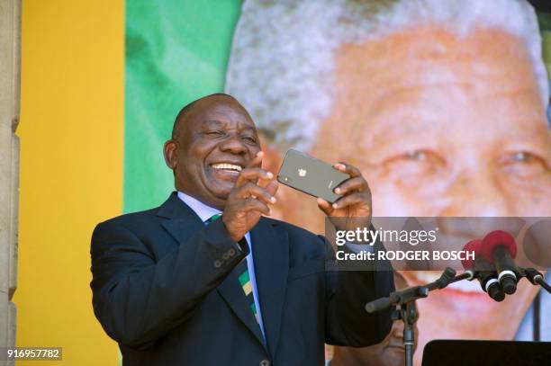 South African Deputy President and newly-elected president of the ruling African National Congress , Cyril Ramaphosa holds up a mobile phone during a...