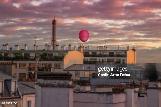 red helium balloon flying above paris during sunset with eiffel tower. - sassy paris stock pictures, royalty-free photos & images