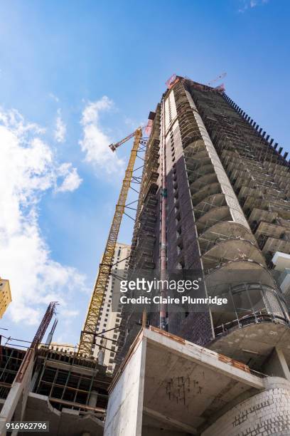 construction crane at the side of a building in dubai - taken from below looking up. - claire plumridge stock-fotos und bilder