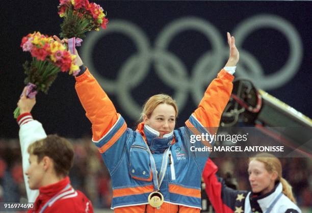 Marianne Timmer of the Netherlands raises her arms on podium after winning her second gold medal of the Nagano Olympics in the women's 1,000 metre...