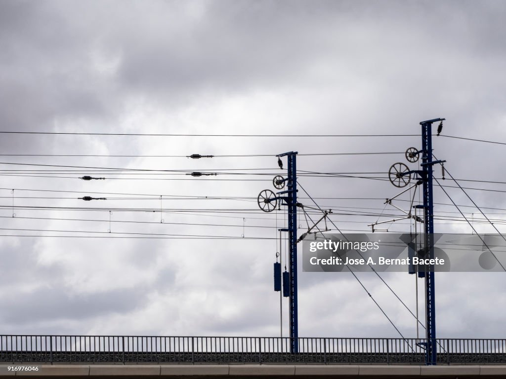 Railroad track of the high-speed train AVE on a bridge, with his electrical towers and	catenary. Valencia, Spain