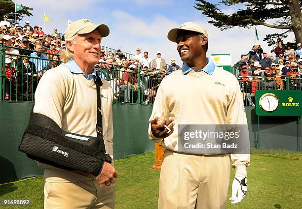 International team captain Greg Norman, left, and Vijay Singh playing for the International team chat on the first tee during the second round...